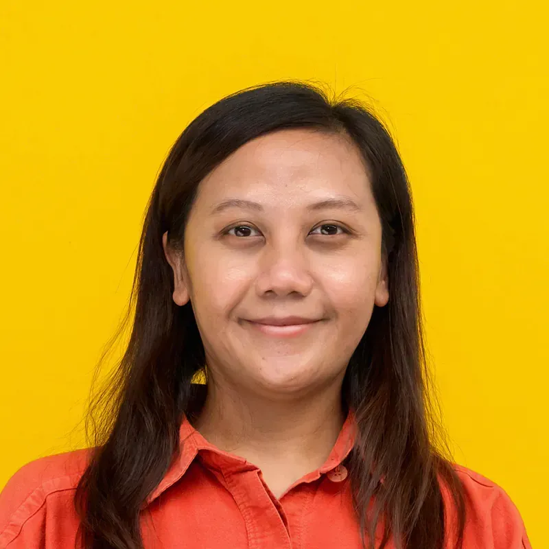 A woman with long dark hair and red lipstick is smiling for the camera.