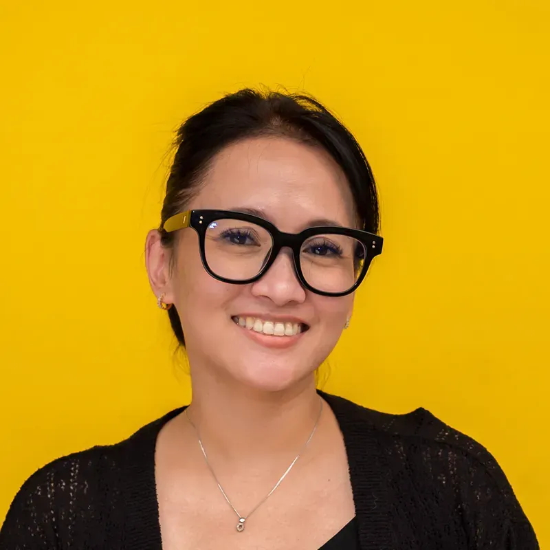 A woman with short black hair is smiling for the camera