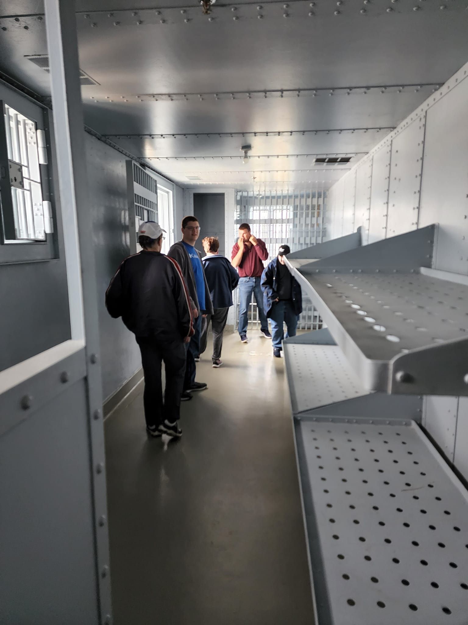 a group of people are walking down a hallway in a building .