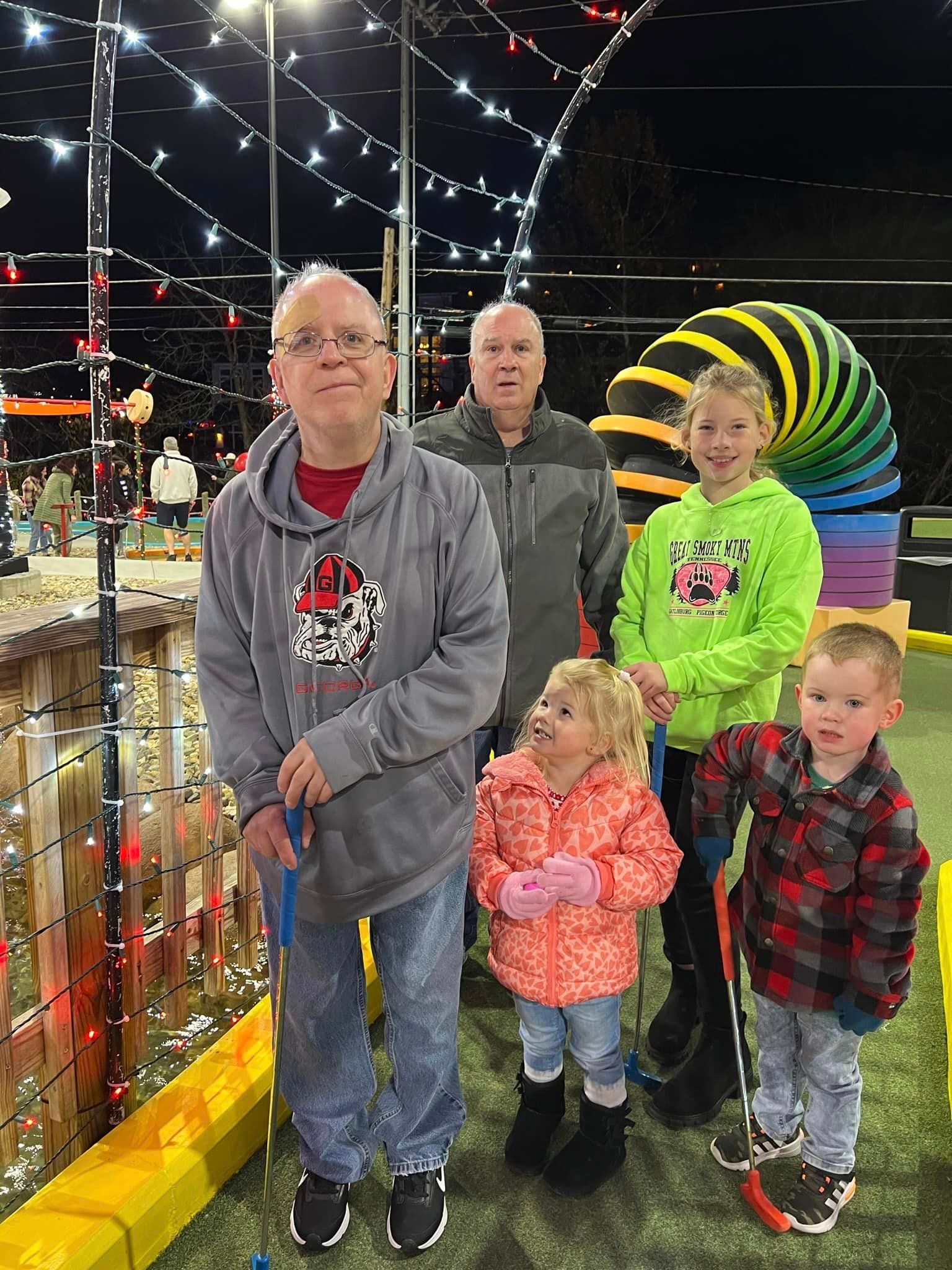 a group of people standing next to each other on a golf course .