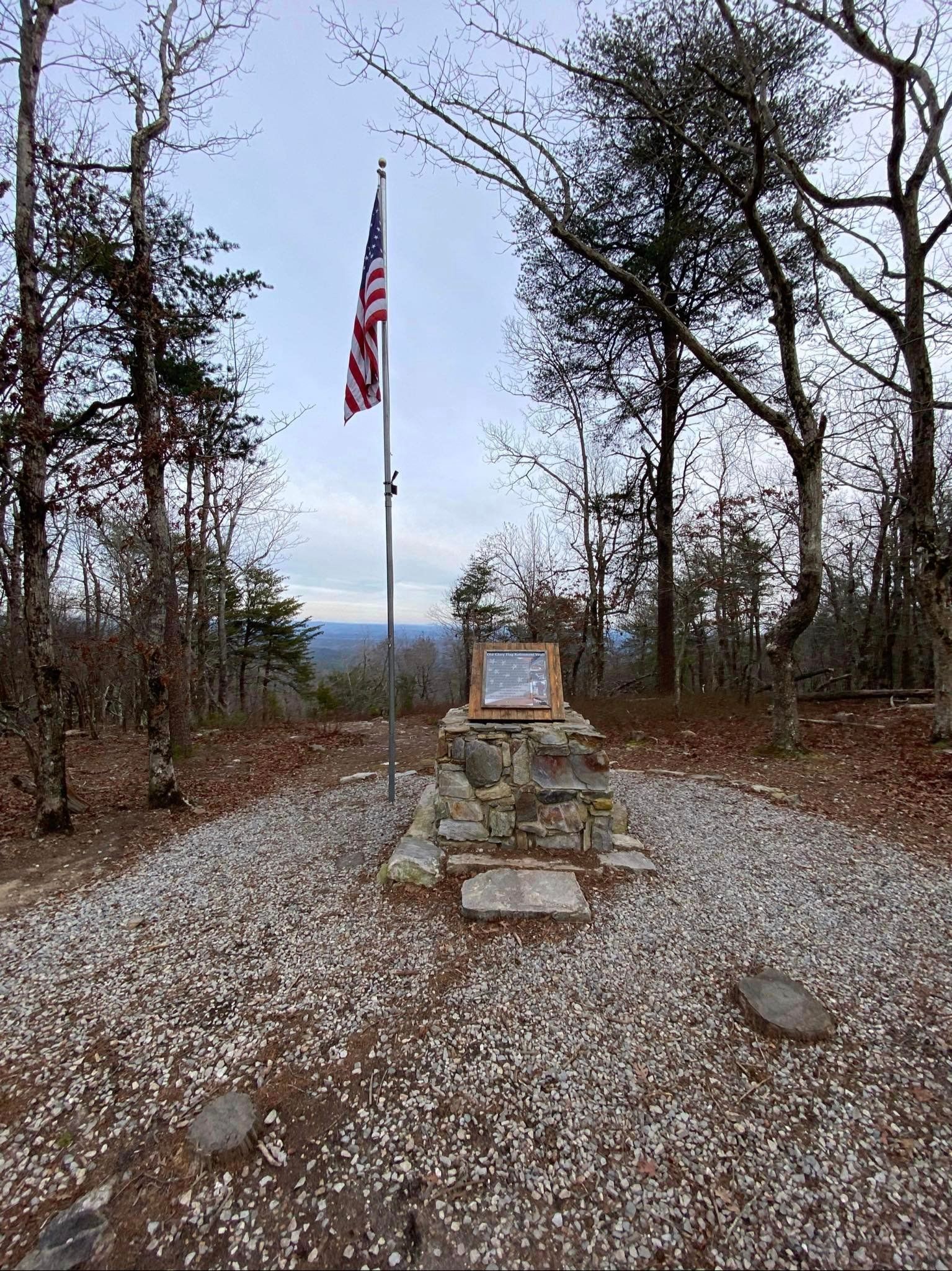 an american flag is flying in the middle of a gravel area