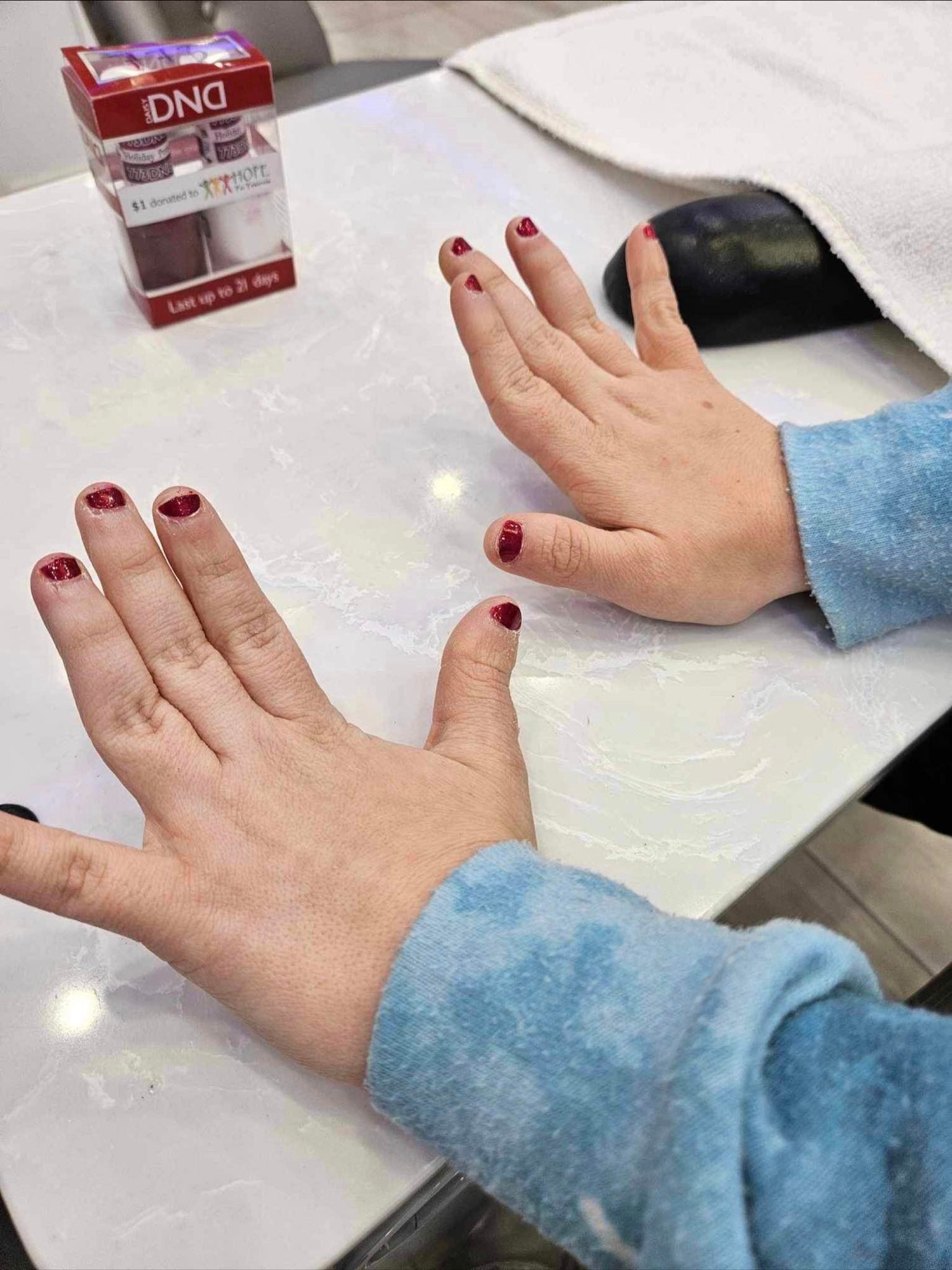 a woman 's hands with red nail polish on them