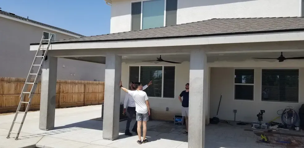 A group of people are standing in front of a house.