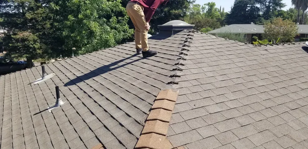 A man is working on the roof of a house.