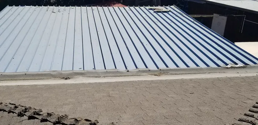 A blue metal roof is sitting on top of a concrete floor.