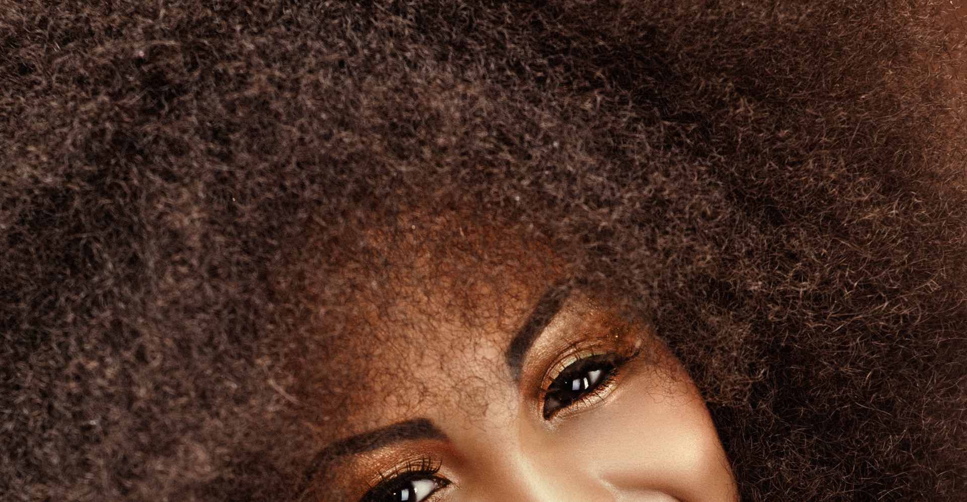 A close up of a woman 's face with black hair and green eyes.