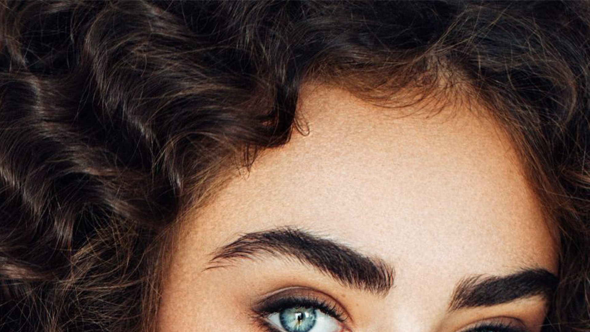 A close up of a woman 's face with long hair.
