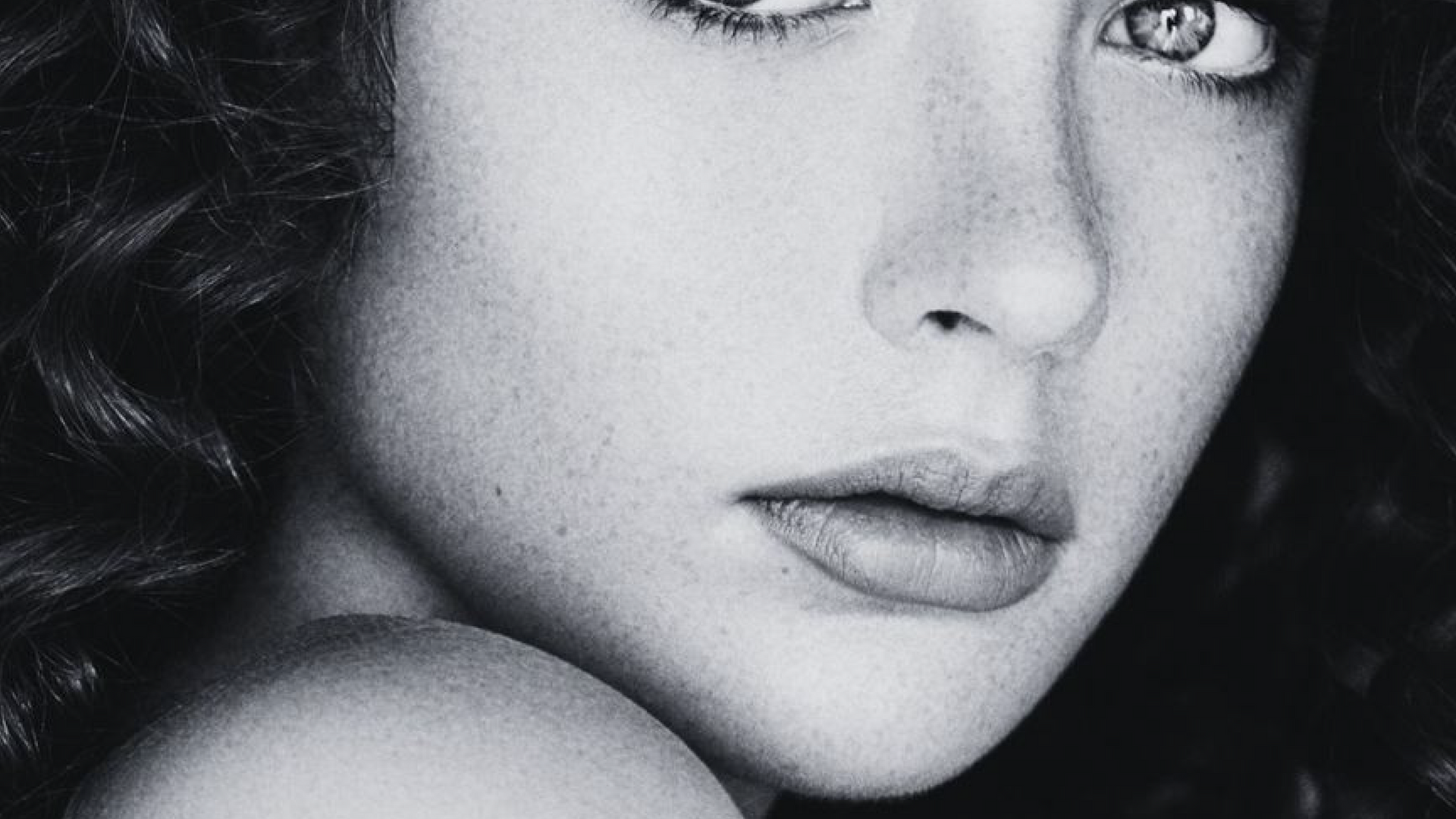 A close up of a woman 's face with long hair.
