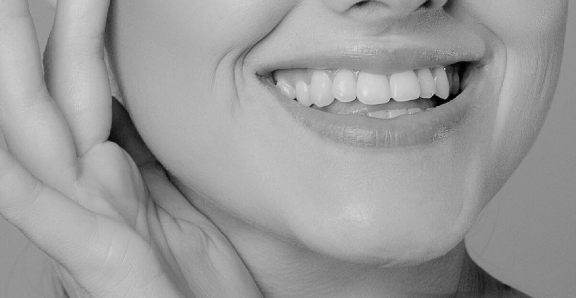 A close up of a woman 's face with her hand on her ear.