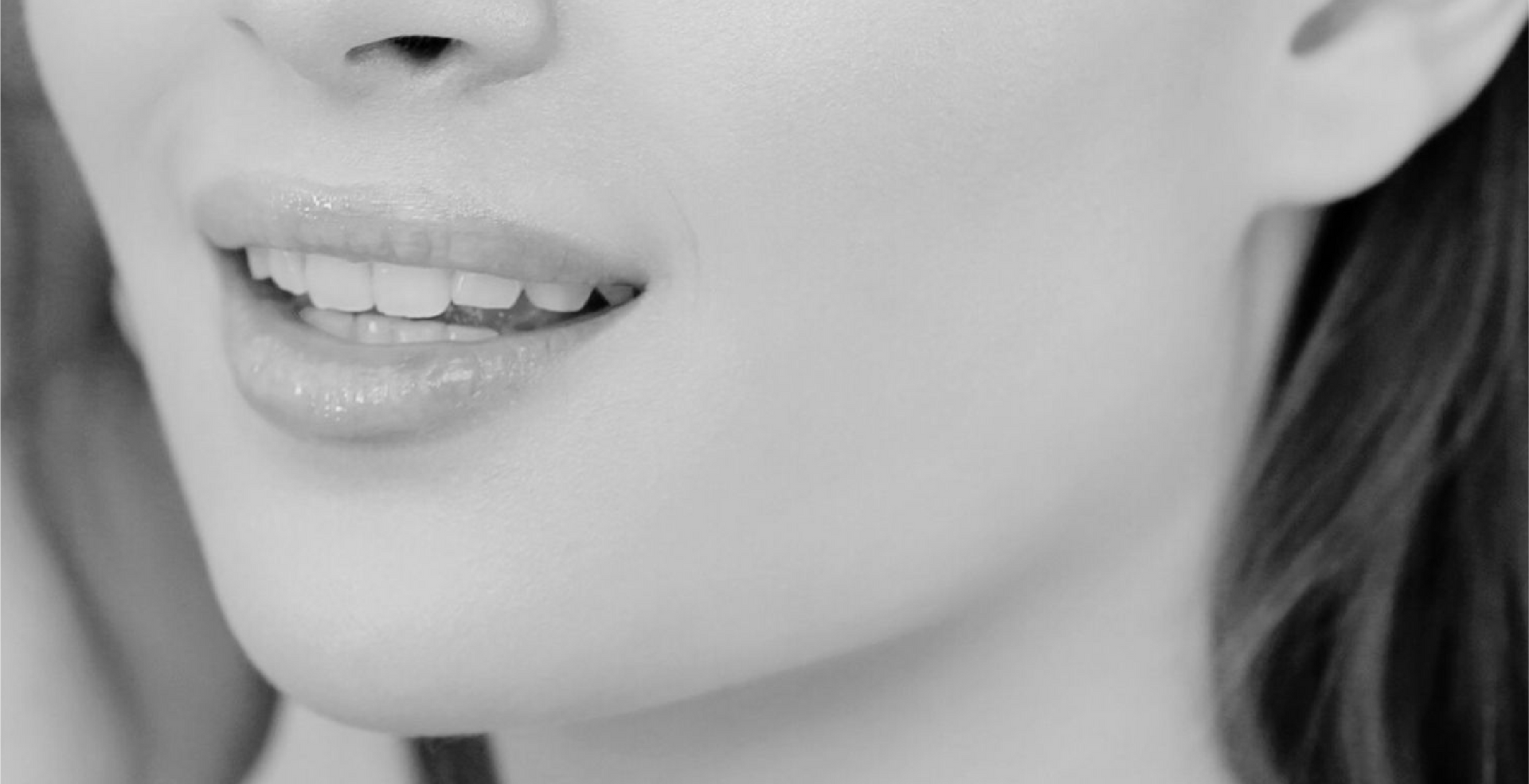 A black and white photo of a woman 's face with her mouth open.