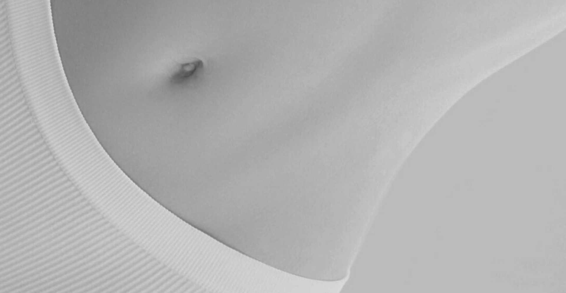 A black and white photo of a woman 's belly.