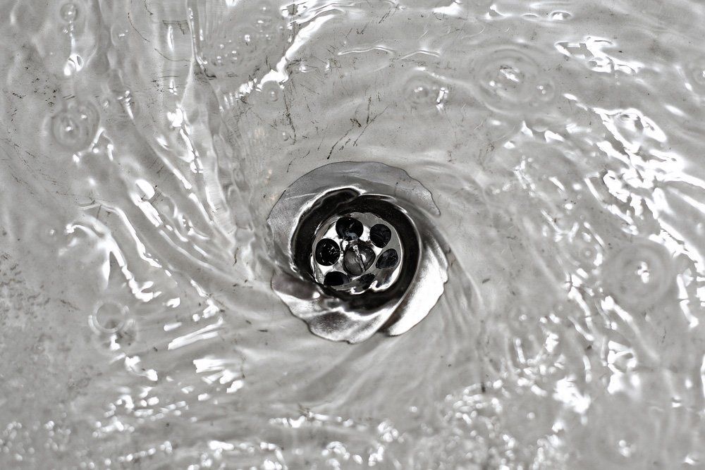 A Close Up of a Sink With Water Running Down the Drain — Houley's Hot Water & Plumbing Wollongong in Russell Vale, NSW