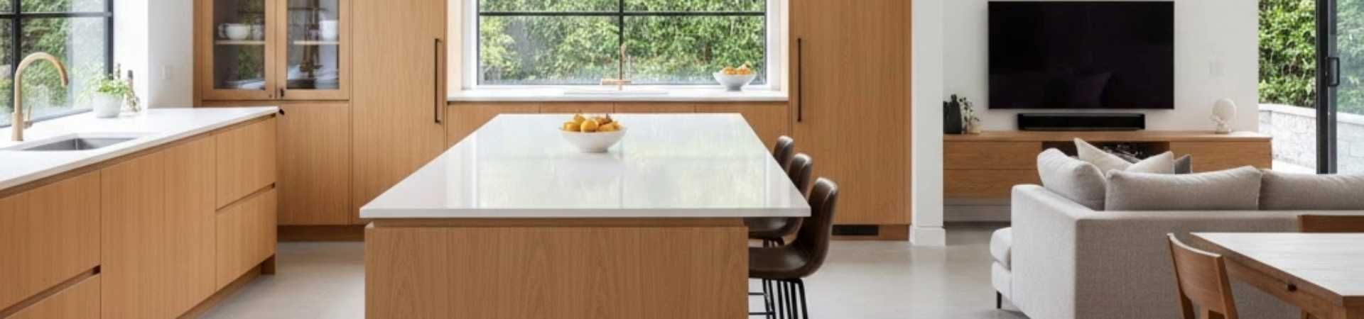 Open-concept kitchen with large island and white cabinets showing clear sightlines into the living room.