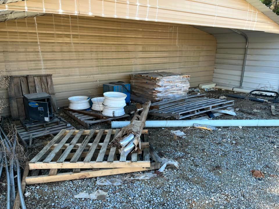 A pile of wooden pallets and buckets in front of a building.