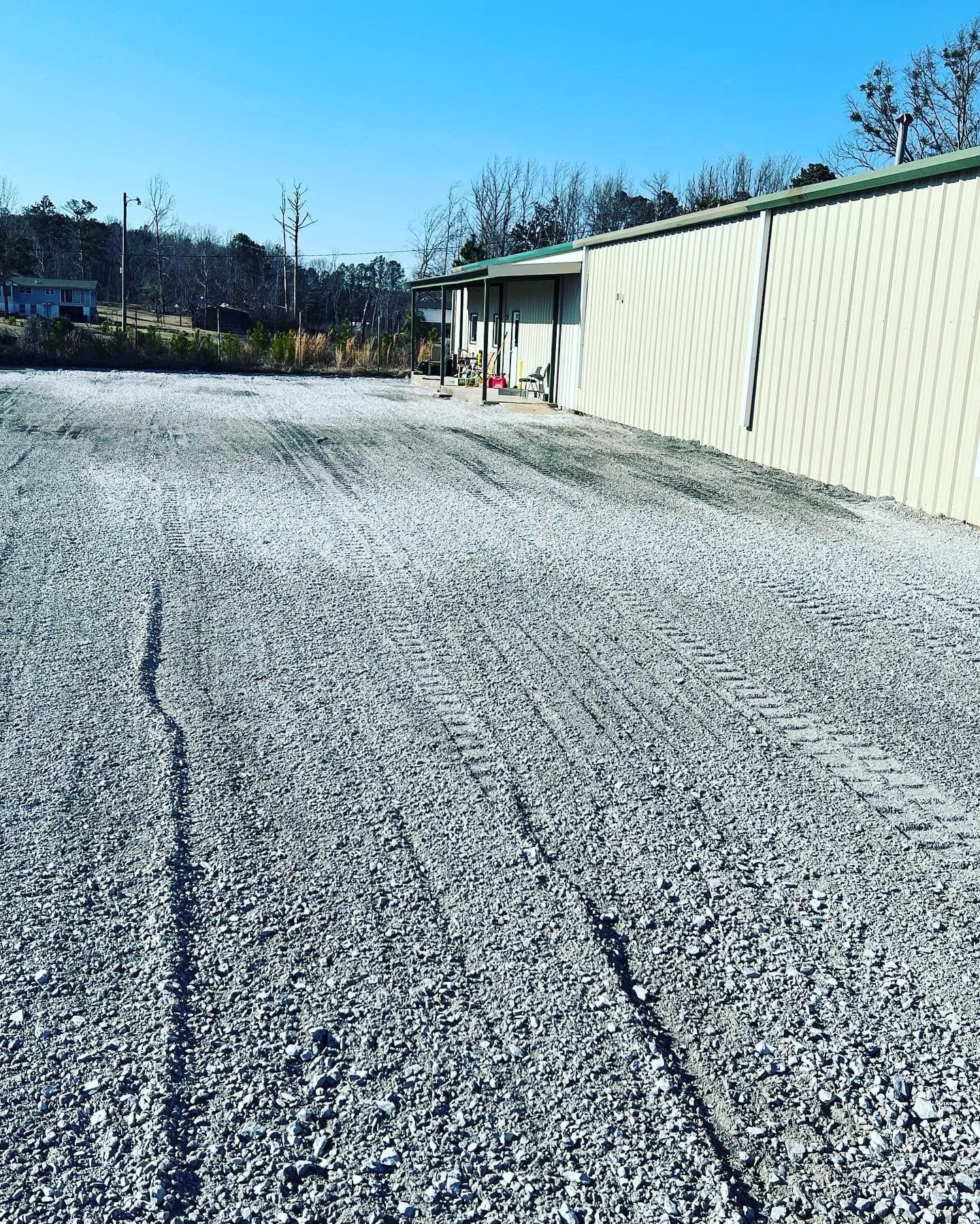 A gravel road with a building in the background.