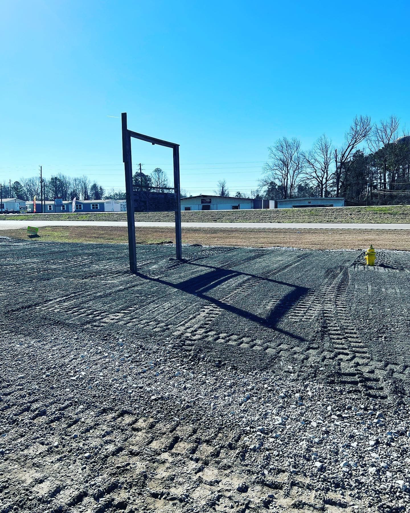 A pull up bar is sitting in the middle of a dirt field.