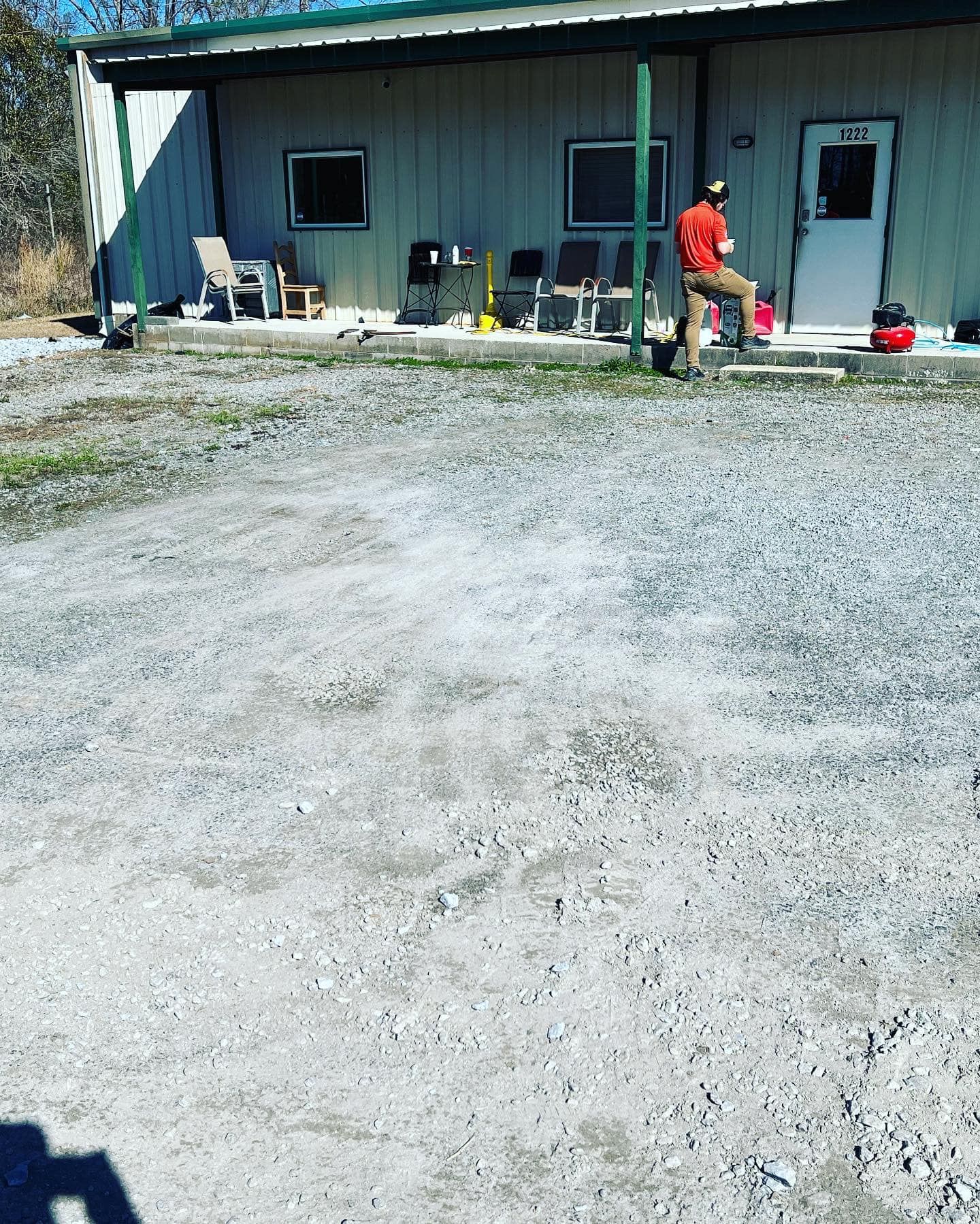 A man is sitting on a bench in front of a building.