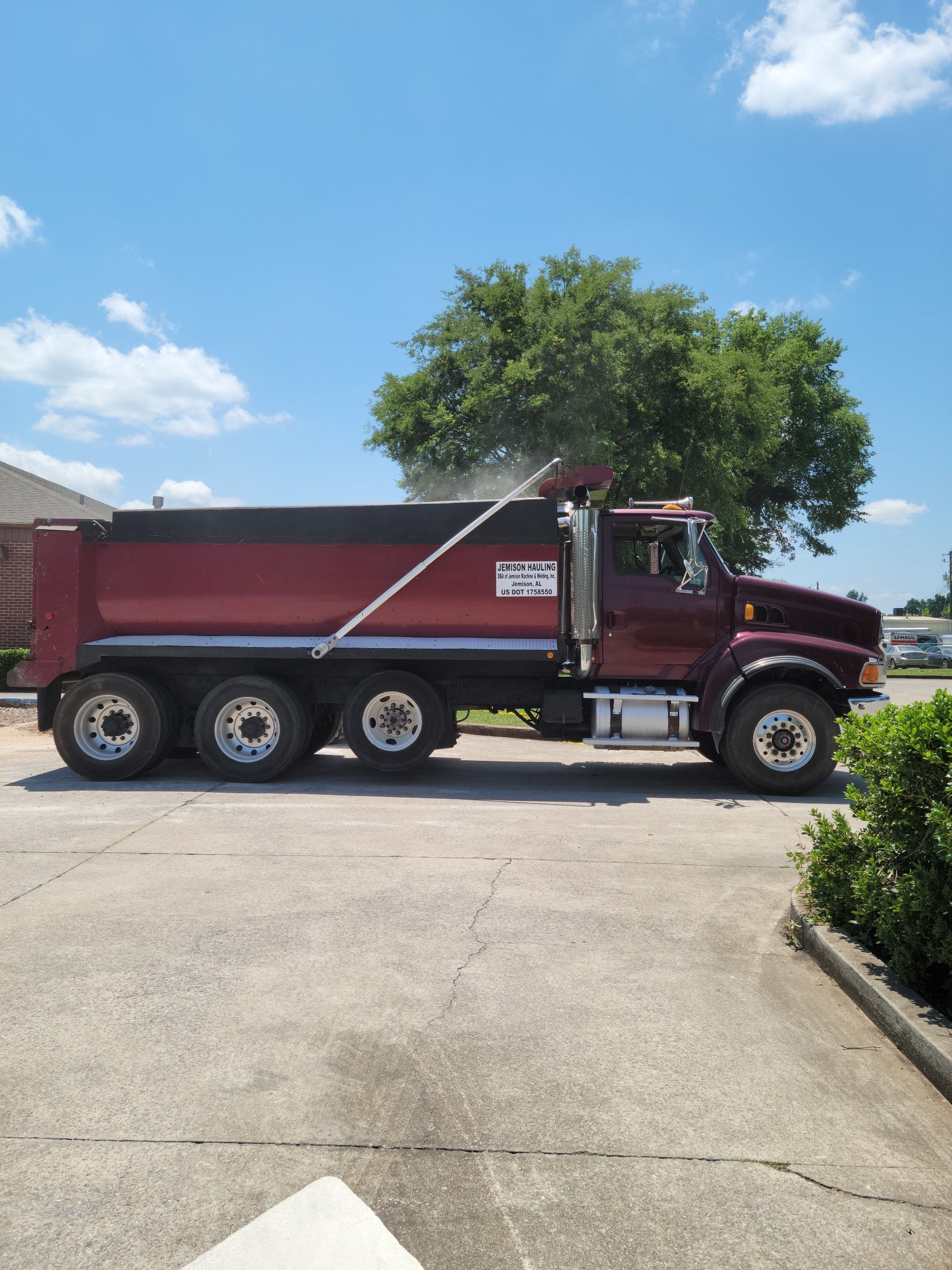 A red dump truck is parked in a parking lot.