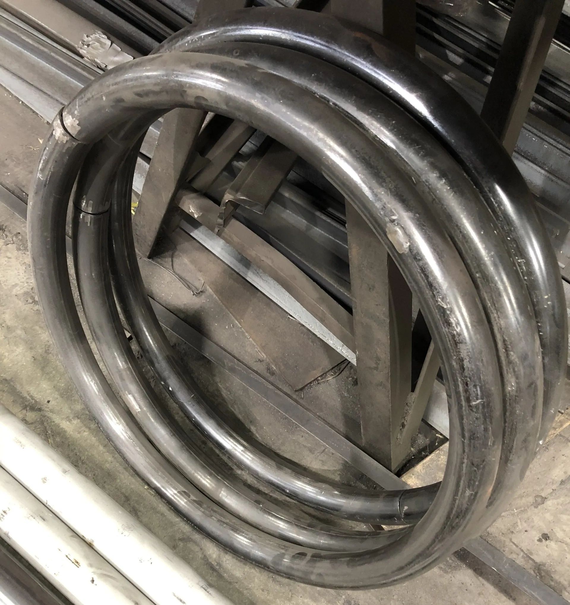 Coiled metal hose or tubing stacked in a workshop or industrial setting