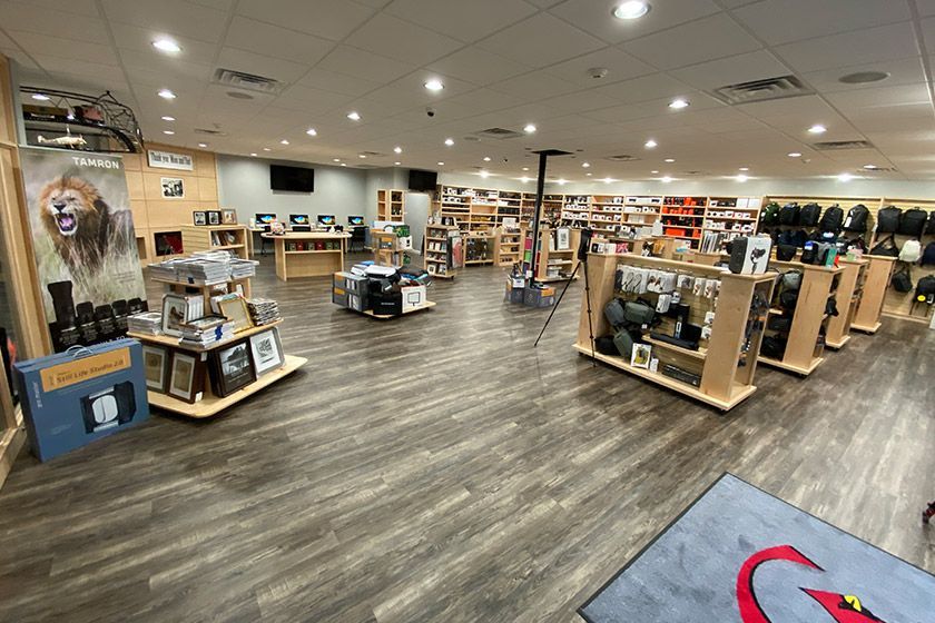 Interior of a retail store with backpacks and bags displayed on walls and shelving.