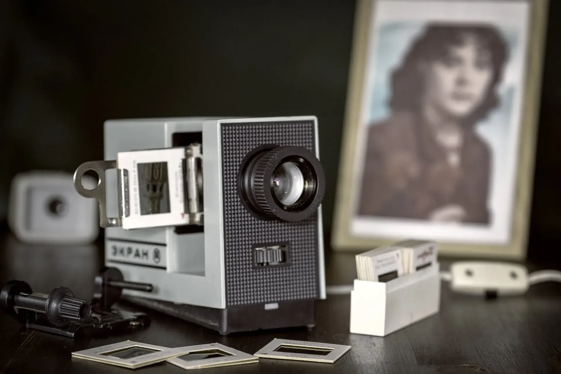 Vintage slide projector with slides and a framed photo.