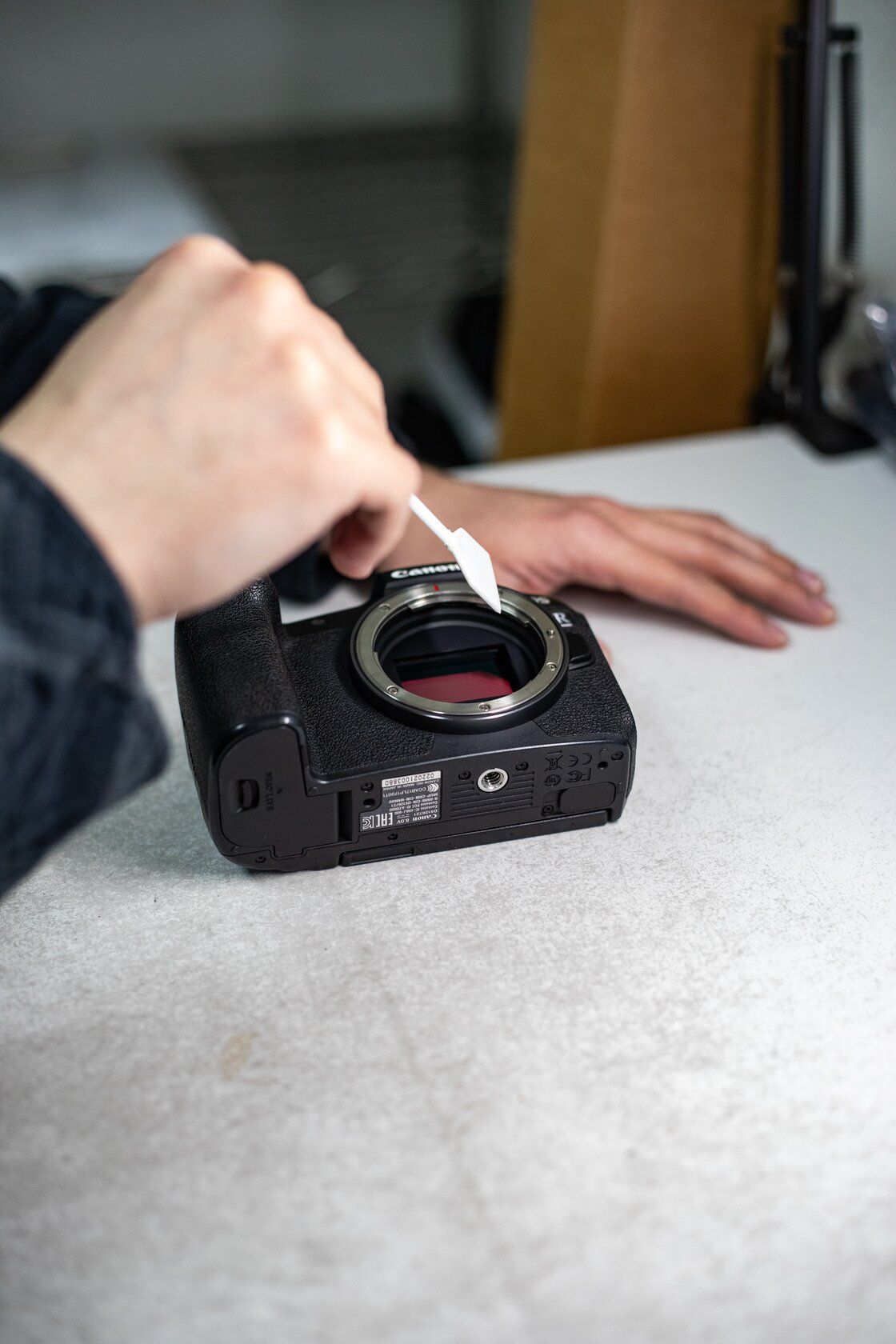 Black Ricoh KR-10 camera with a lens, sitting on a surface. The lens reflects a colorful scene.