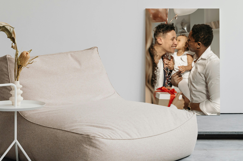 A modern living room with a beanbag chair, side table, and a family photo on the wall.