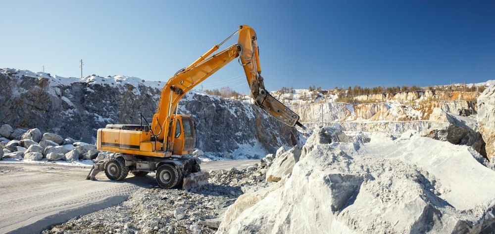 An Excavator Mining in a Quarry on a Clear Day — Cairns Earthmoving Solutions In Redlynch, QLD