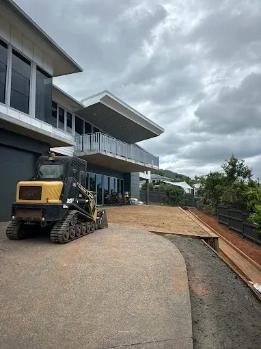 Yellow Excavator outfront of a house— Cairns Earthmoving Solutions In Gordonvale, QLD