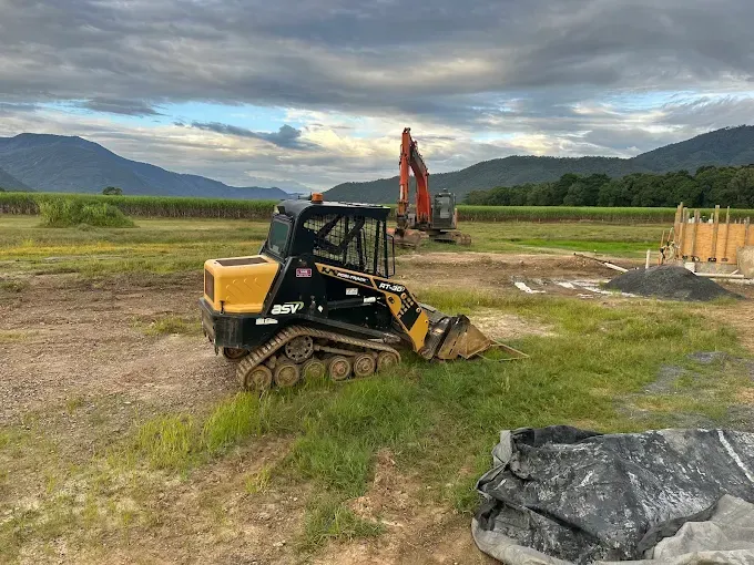 Yellow bobcat in a field — Cairns Earthmoving Solutions In Redlynch, QLD