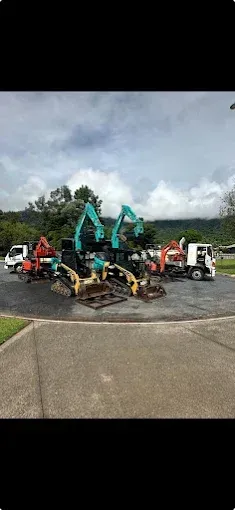Multiple machines on the road in front of trees — Cairns Earthmoving Solutions In Redlynch, QLD