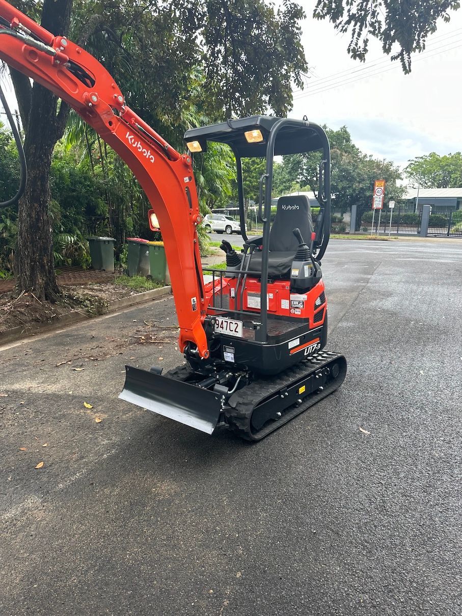 Red bobcat on a wet road— Cairns Earthmoving Solutions In Holloways Beach, QLD