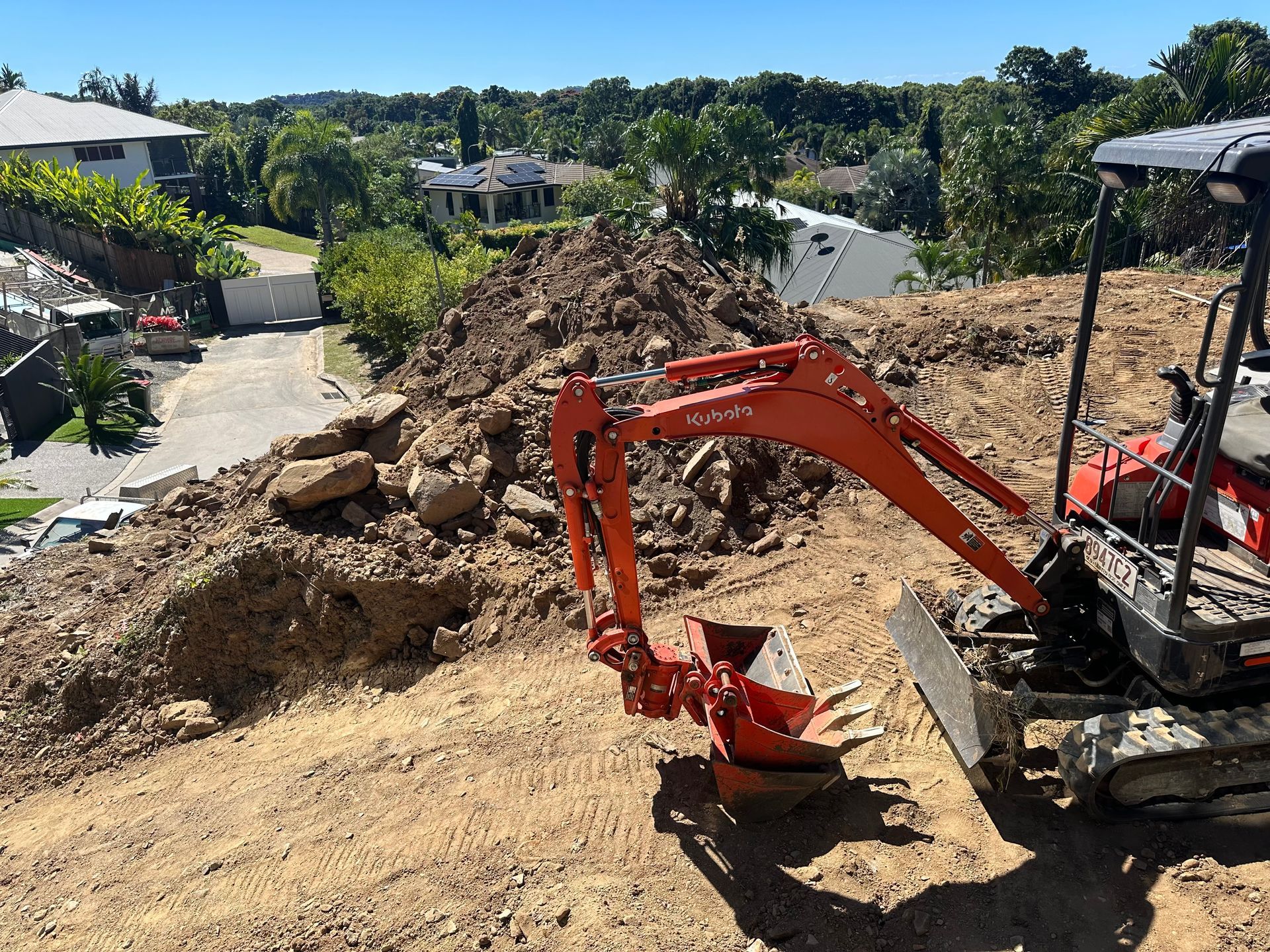 A Yellow Excavator in the air — Cairns Earthmoving Solutions In Redlynch, QLD