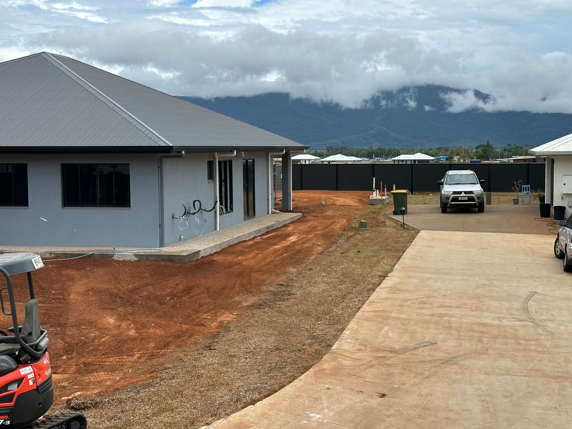 Bobcats parked out front of new built houses — Cairns Earthmoving Solutions In Redlynch, QLD