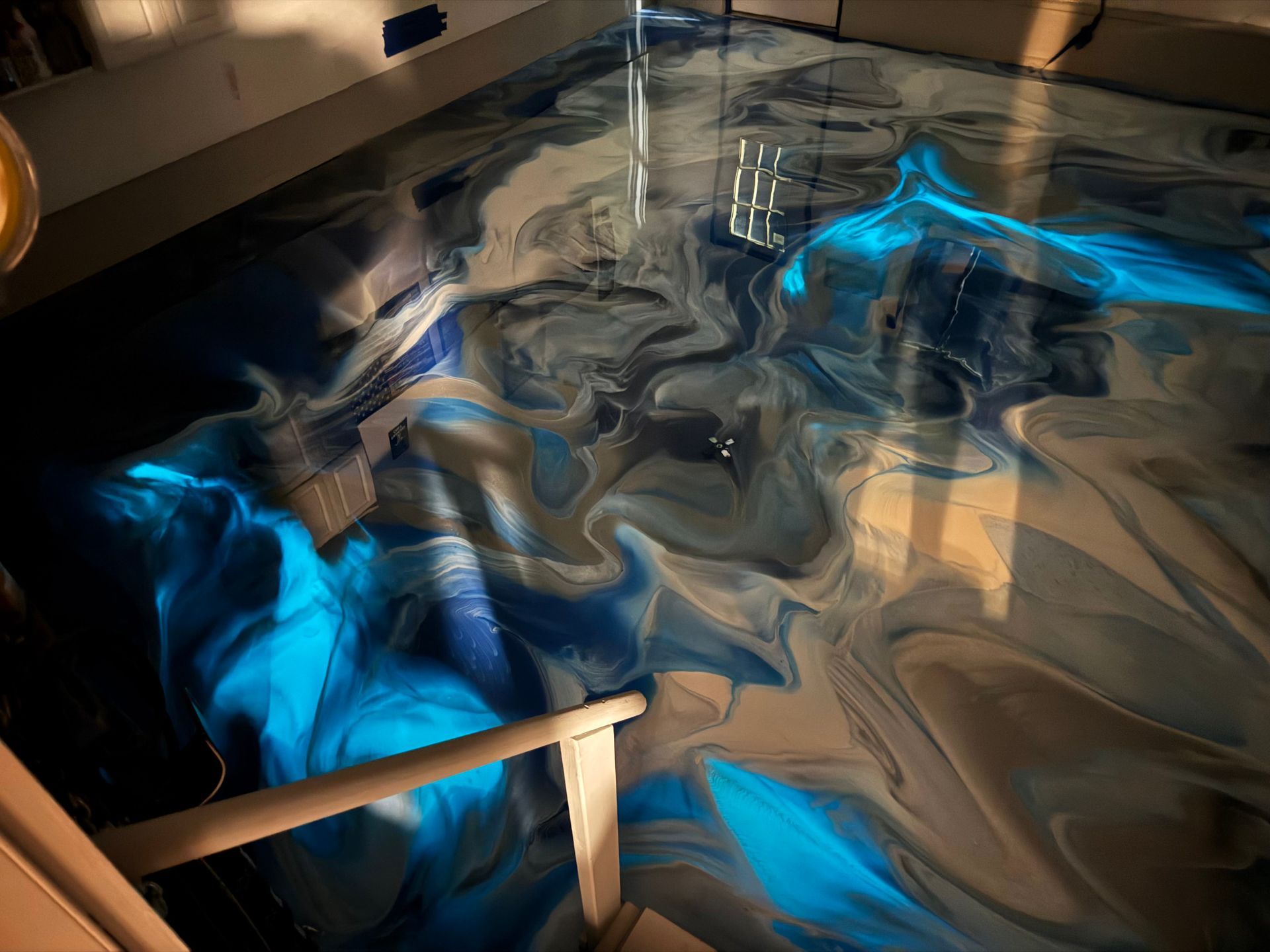 Abstract blue and tan marbled surface with glossy swirls and reflections