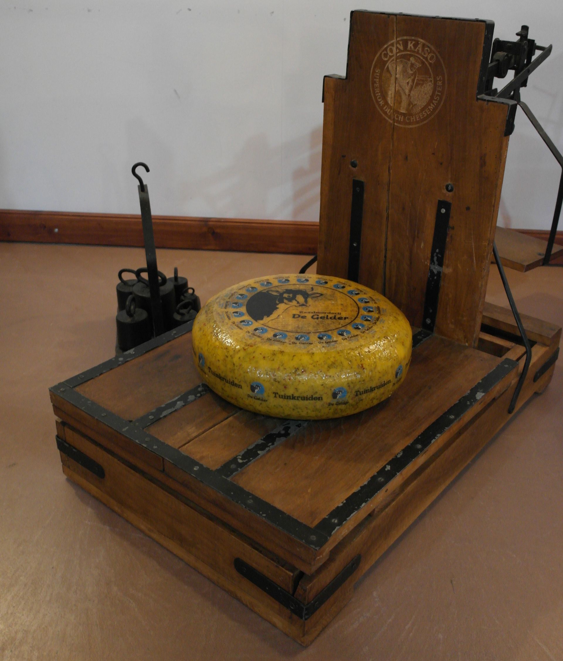 Runder, gelber Käselaib mit Kuh-Logo und der Aufschrift 