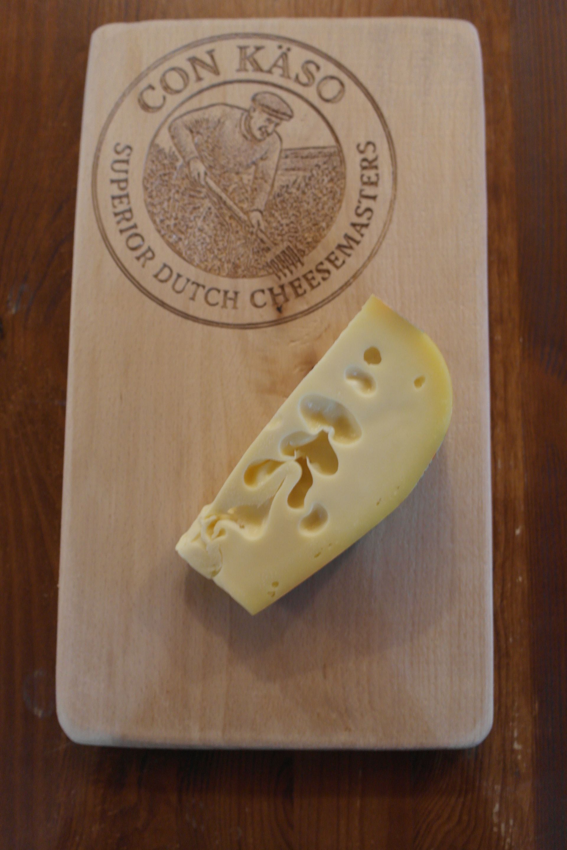 Ein gelber Käselaib mit der Aufschrift „Tynjetaler“ und einem keilförmigen Deckel mit Löchern.