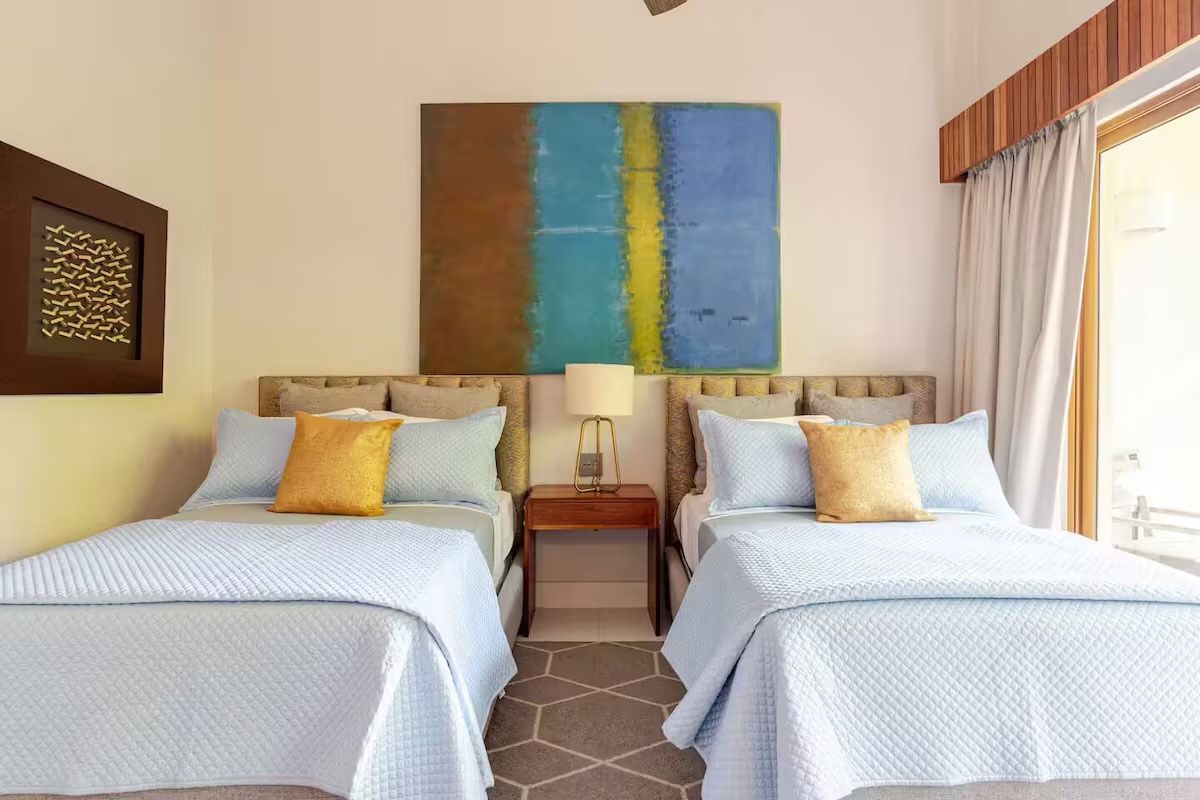 a bedroom with a bed, dresser, television and a picture of jack sparrow on the wall