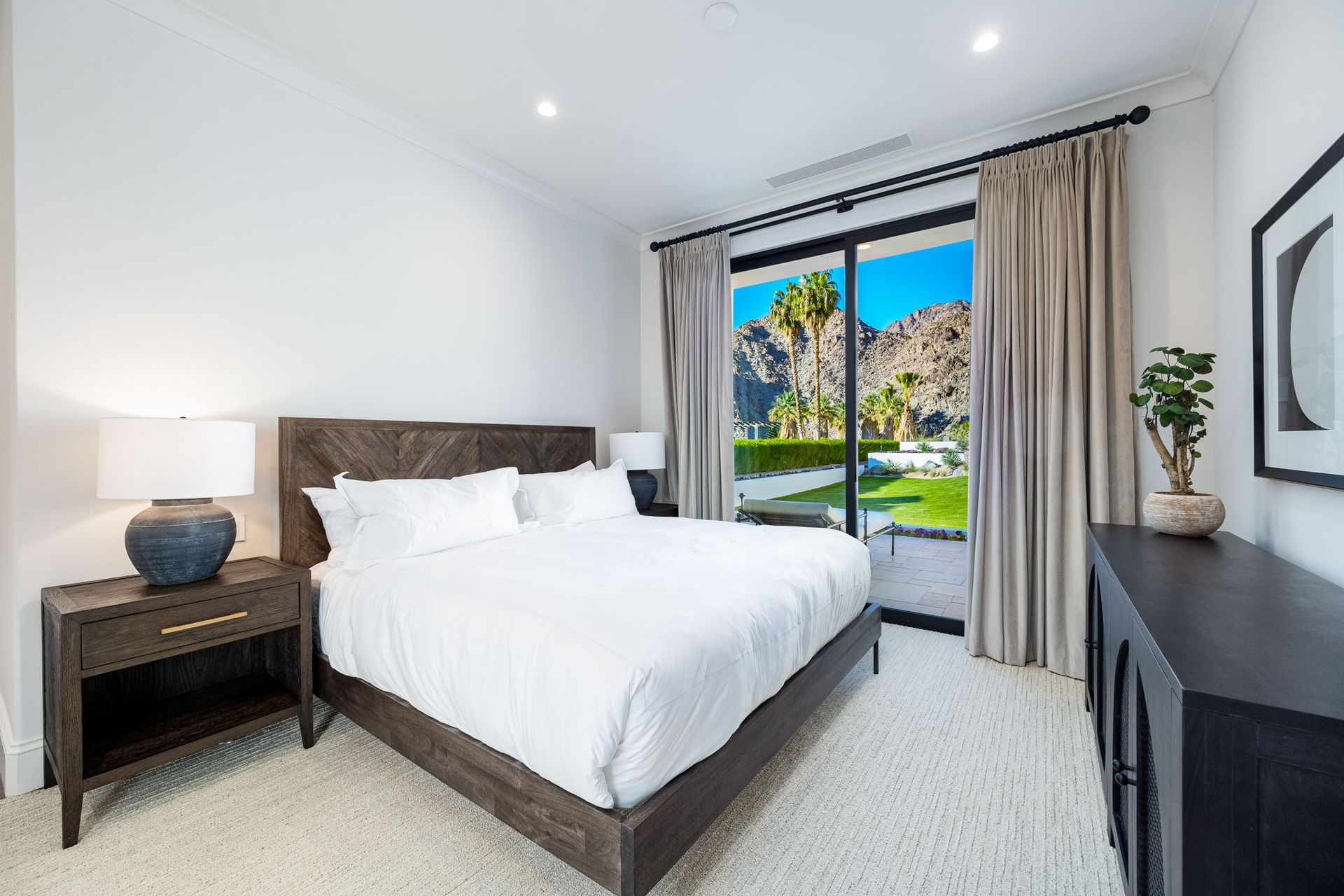 A bedroom with a king size bed and a sliding glass door.