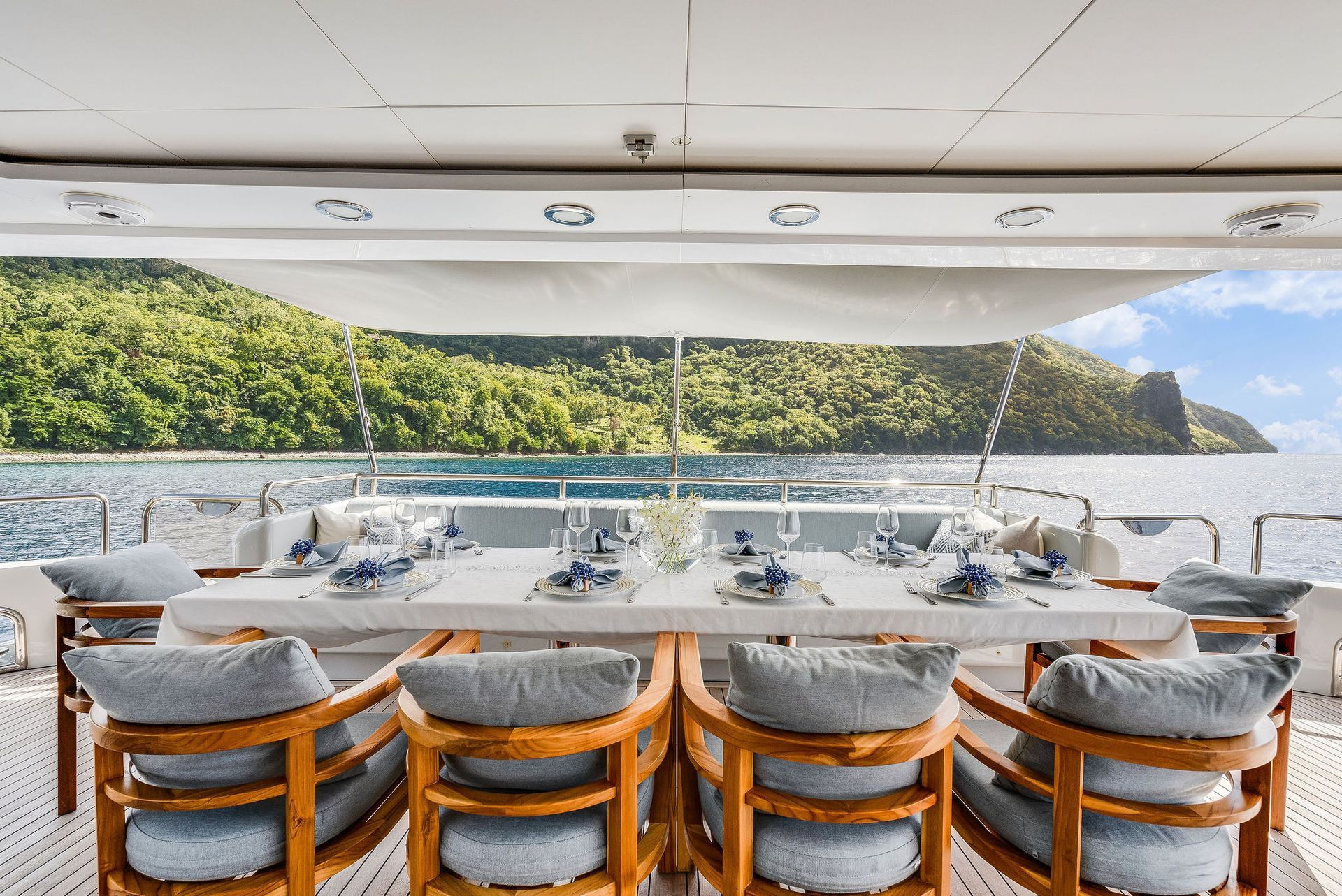 there is a large table and chairs on the deck of a yacht