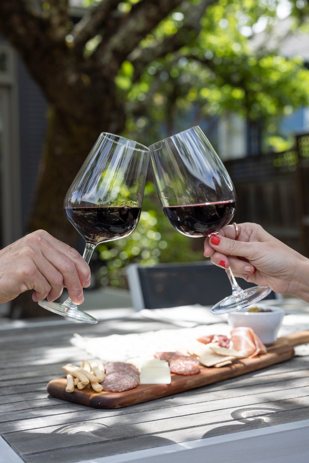 two people are toasting with wine glasses at a table
