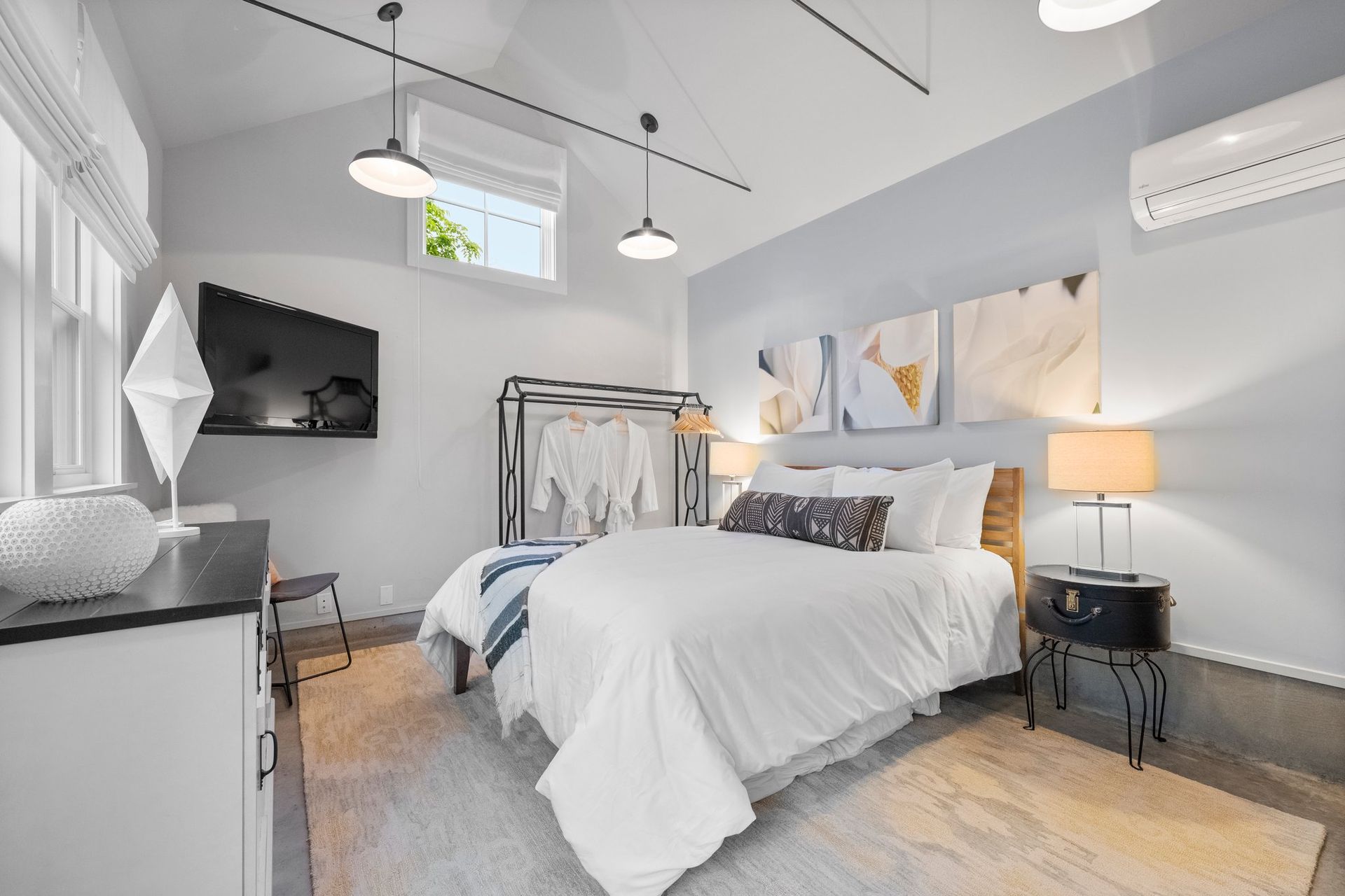 a bedroom with a large bed and a flat screen tv on the wall