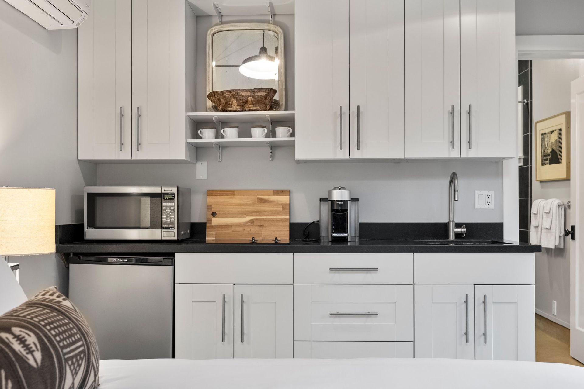 a kitchen with white cabinets, a microwave, a dishwasher and a sink