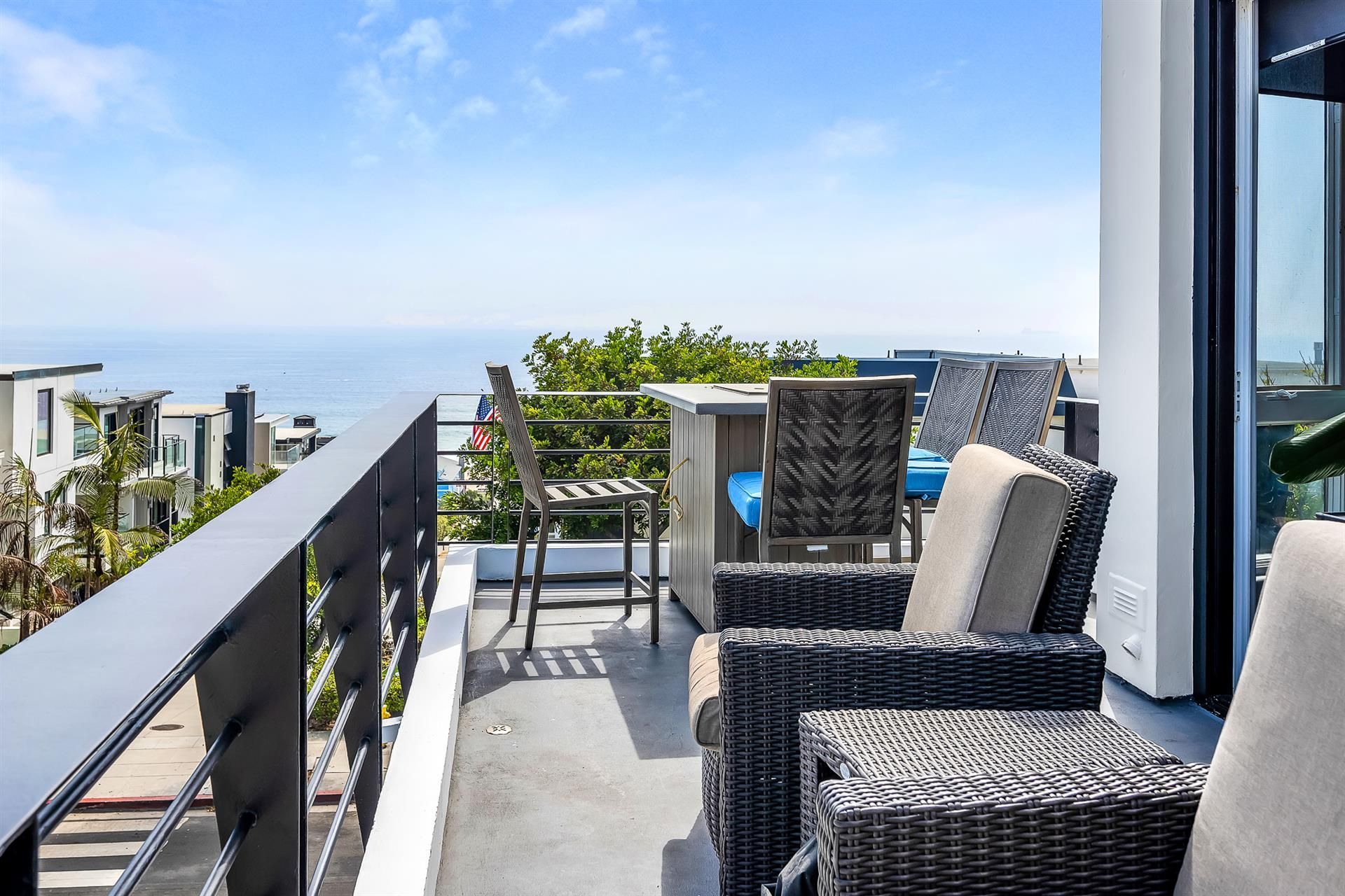 A balcony with wicker furniture and a view of the ocean.