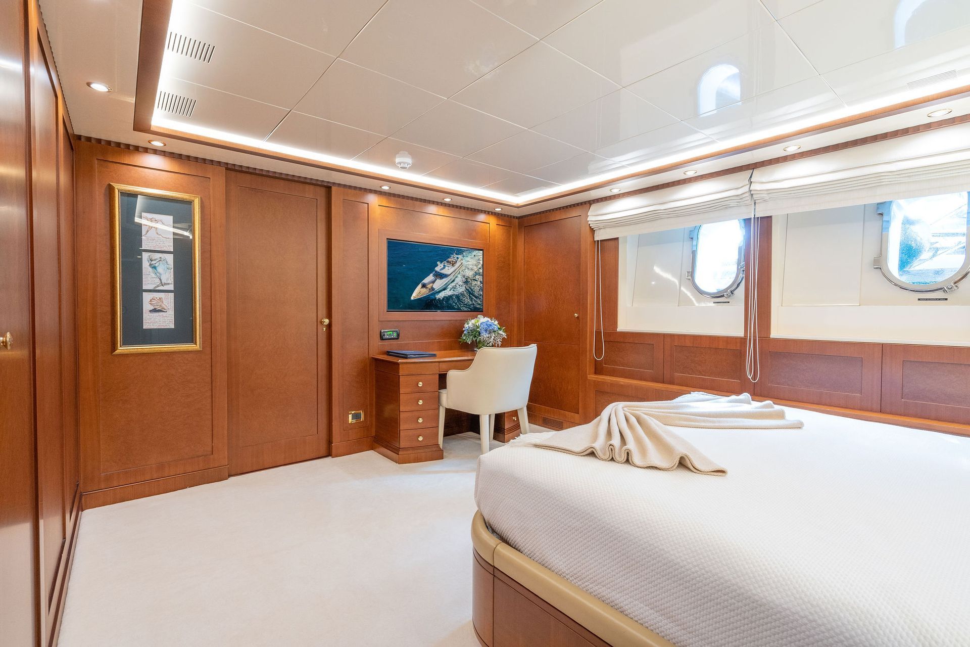 a bedroom on a yacht with a large bed and a desk