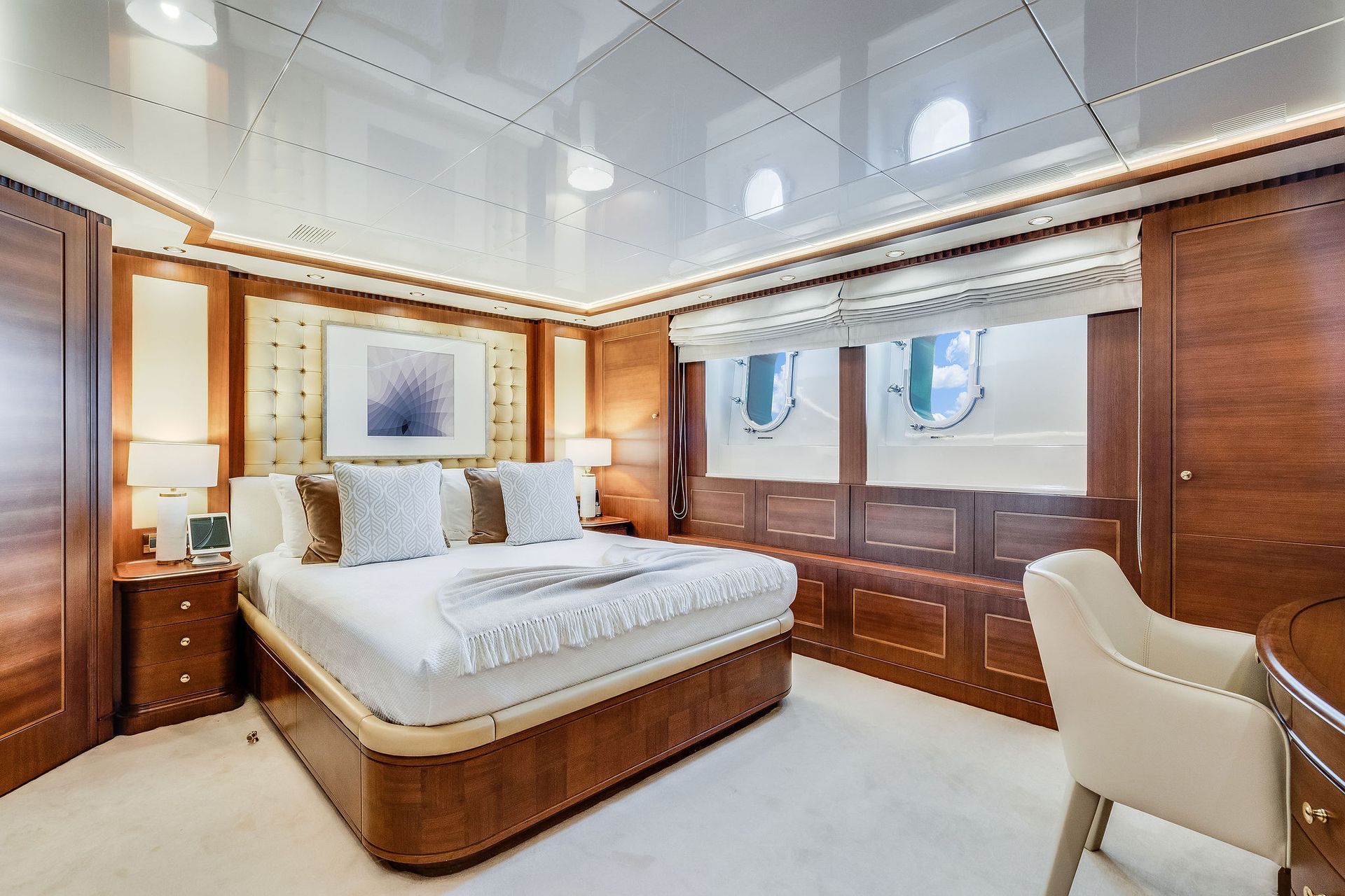 a bedroom on a yacht with a large bed and a desk