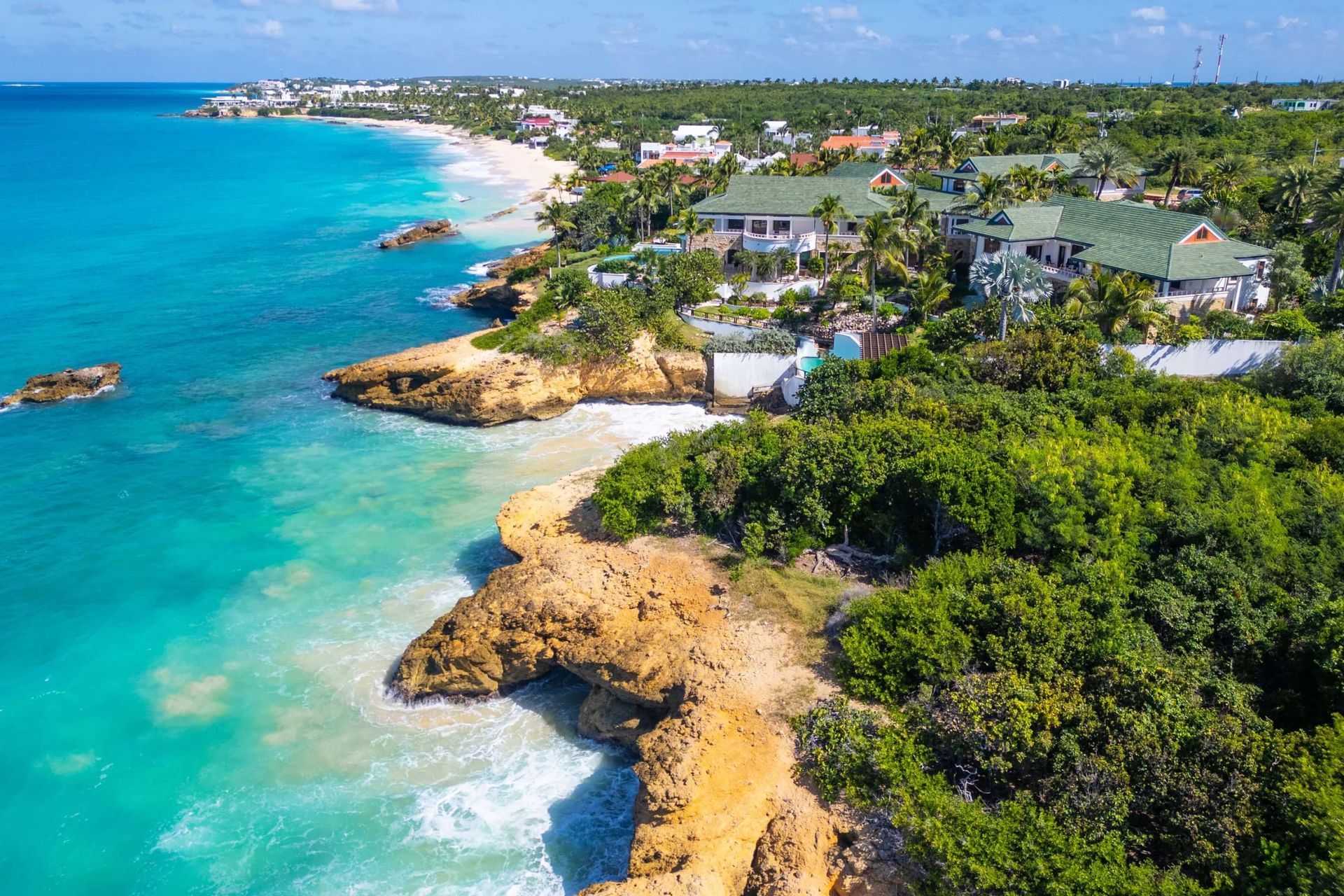An aerial view of a tropical island with a beach and trees.