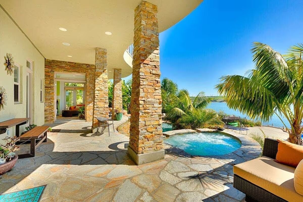 a large patio with a swimming pool and a view of a lake