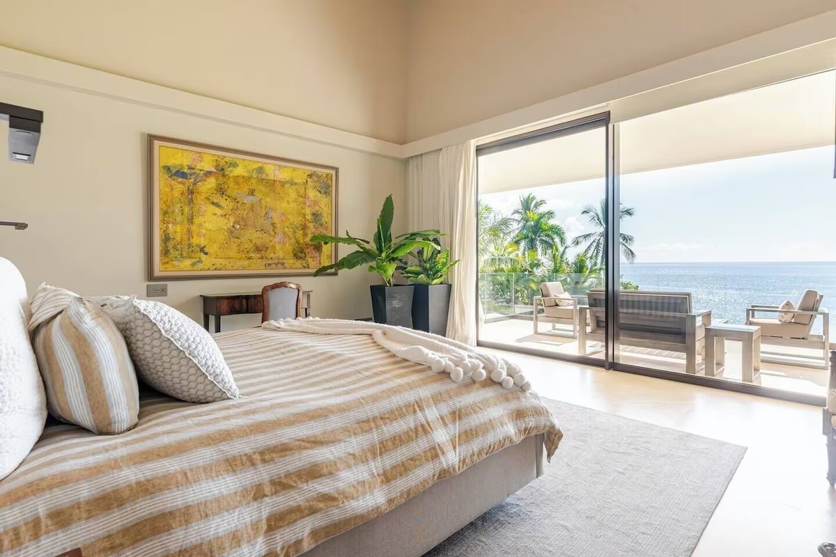 a bedroom with a large bed, two chairs and a ceiling fan