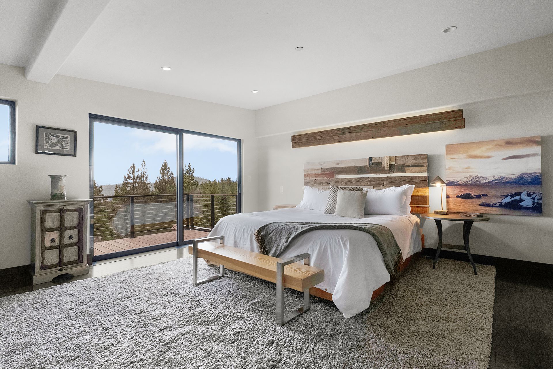 a bedroom with a large bed, dresser, nightstand and sliding glass doors